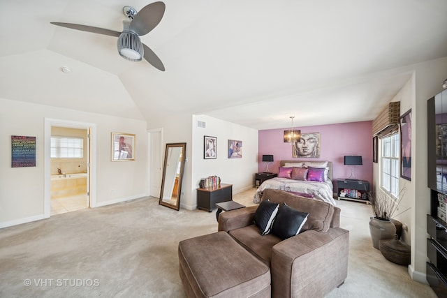 bedroom with vaulted ceiling, light carpet, ensuite bathroom, and ceiling fan with notable chandelier