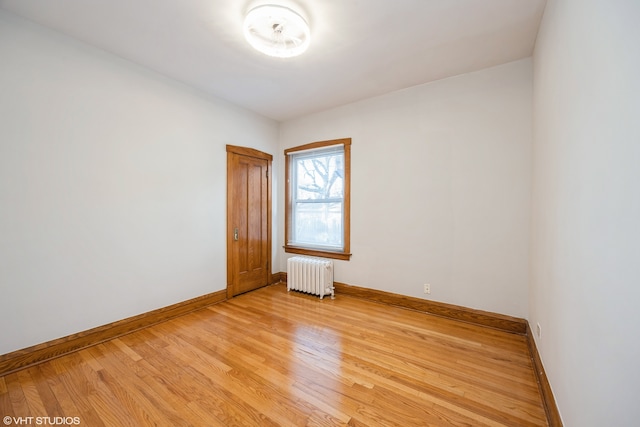 unfurnished room featuring light hardwood / wood-style flooring and radiator