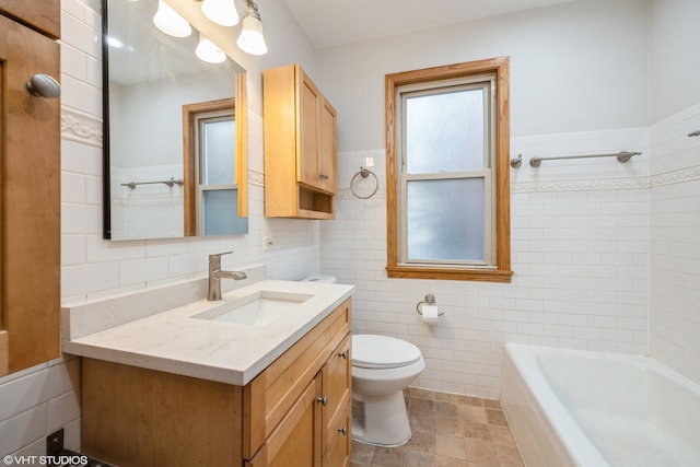 full bathroom with vanity, toilet, tile walls, and tiled shower / bath