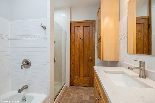 bathroom featuring vanity, tile walls, and shower with separate bathtub