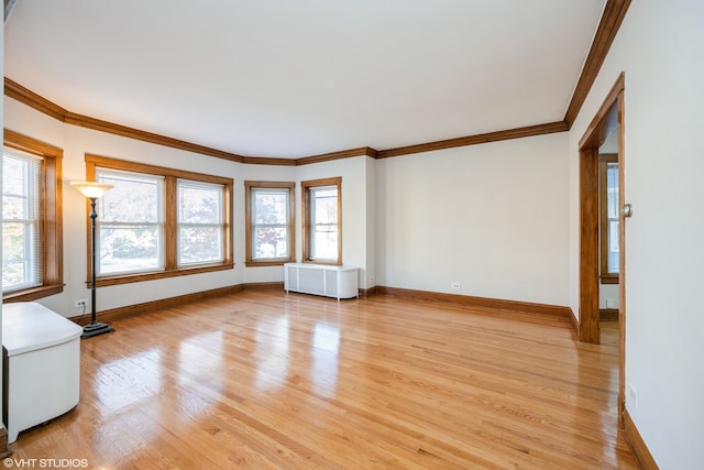 unfurnished living room featuring radiator, light hardwood / wood-style floors, and crown molding