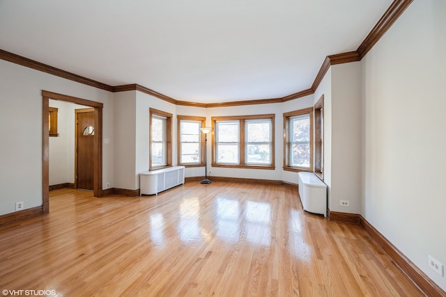 unfurnished room with ornamental molding, radiator heating unit, and light wood-type flooring