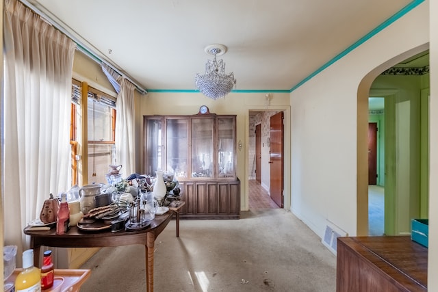 interior space with a chandelier, light colored carpet, and crown molding