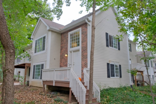 rear view of property featuring a wooden deck