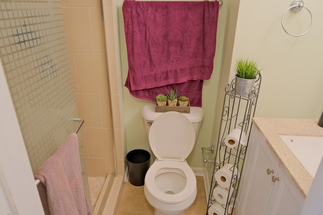 bathroom featuring vanity, tile patterned flooring, toilet, and tiled shower