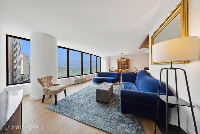 living room featuring a notable chandelier, a water view, and hardwood / wood-style flooring