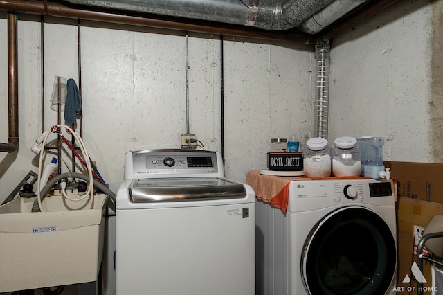 clothes washing area featuring sink and washing machine and clothes dryer