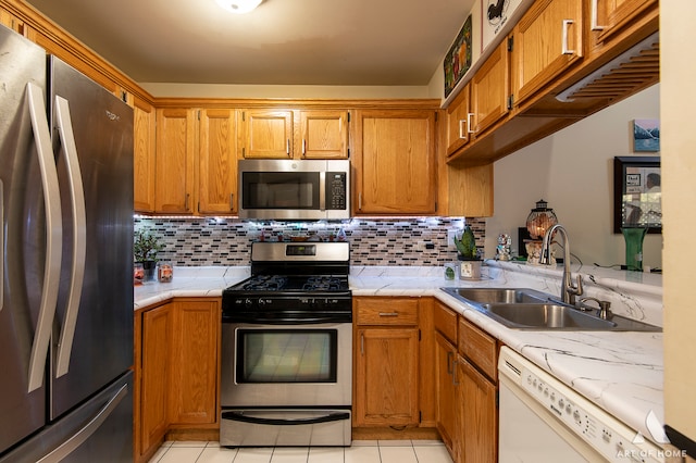 kitchen with decorative backsplash, kitchen peninsula, stainless steel appliances, sink, and light tile patterned floors