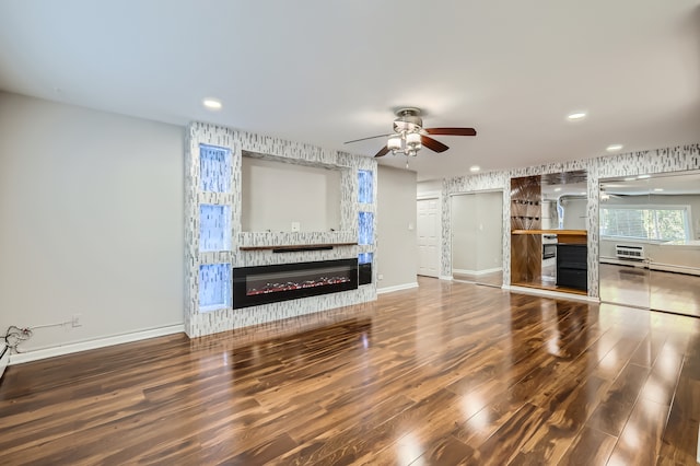 unfurnished living room with ceiling fan and wood-type flooring