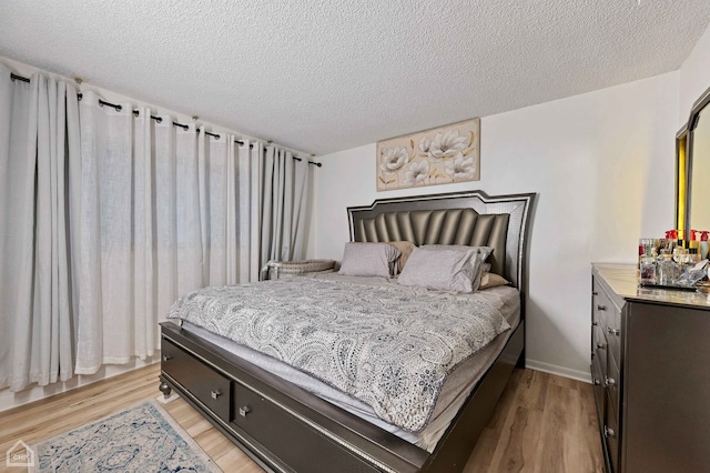 bedroom featuring a textured ceiling and light wood-type flooring