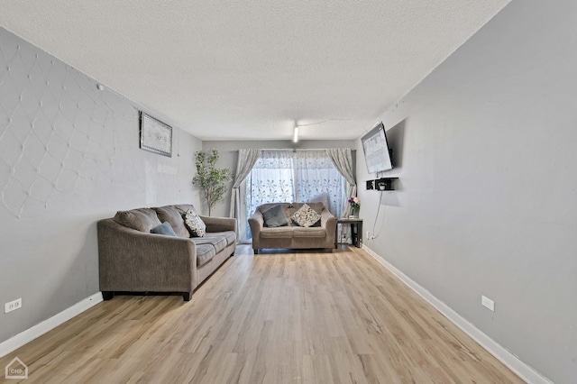 living room featuring light hardwood / wood-style flooring and a textured ceiling