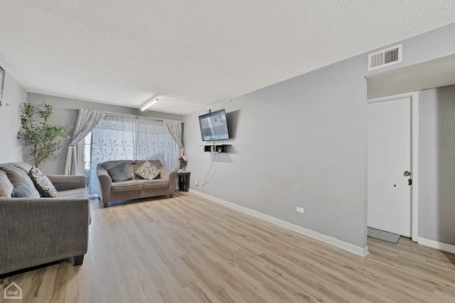 living room featuring a textured ceiling and light hardwood / wood-style flooring