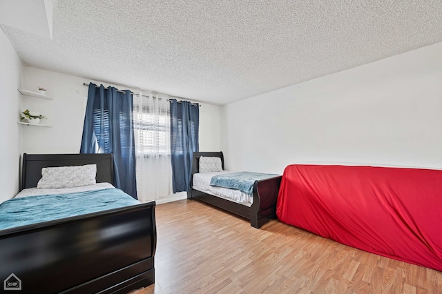 bedroom with hardwood / wood-style flooring and a textured ceiling