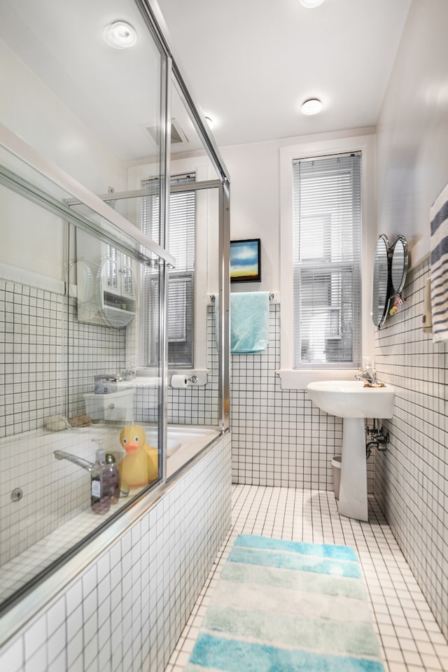 bathroom featuring tile walls, tile patterned flooring, and walk in shower