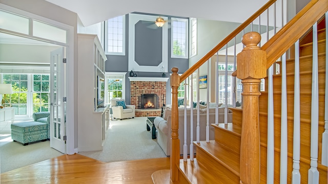 interior space with a brick fireplace, hardwood / wood-style floors, and ceiling fan