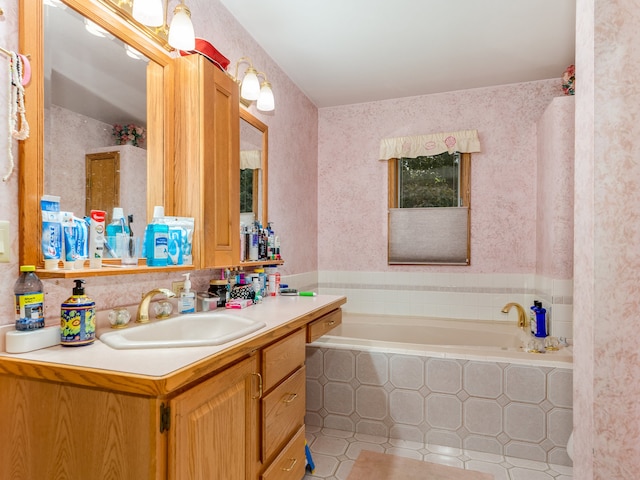 bathroom featuring tile patterned flooring, tiled bath, and vanity