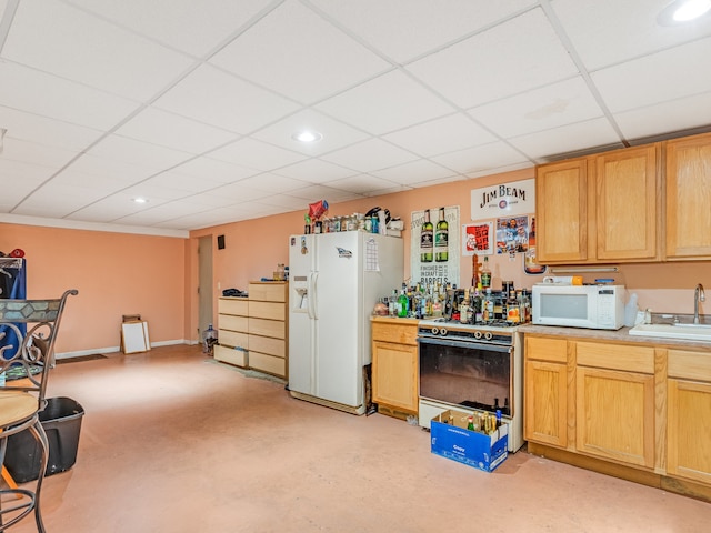 kitchen with a paneled ceiling, sink, and white appliances