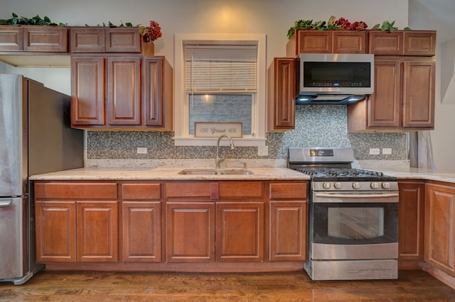 kitchen with sink, backsplash, appliances with stainless steel finishes, dark hardwood / wood-style floors, and light stone countertops