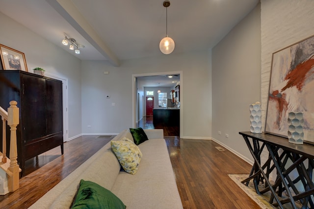 living room with beamed ceiling and dark hardwood / wood-style floors