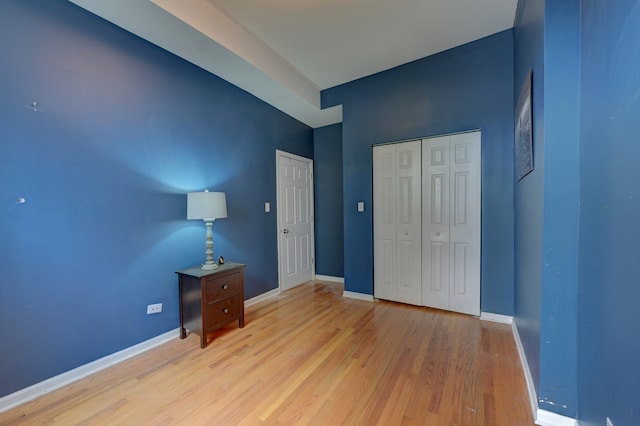 unfurnished bedroom with light wood-type flooring and a closet