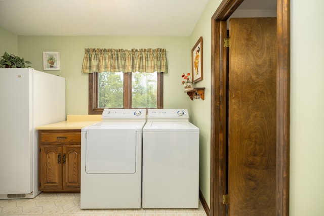 laundry area featuring washer and clothes dryer and cabinets