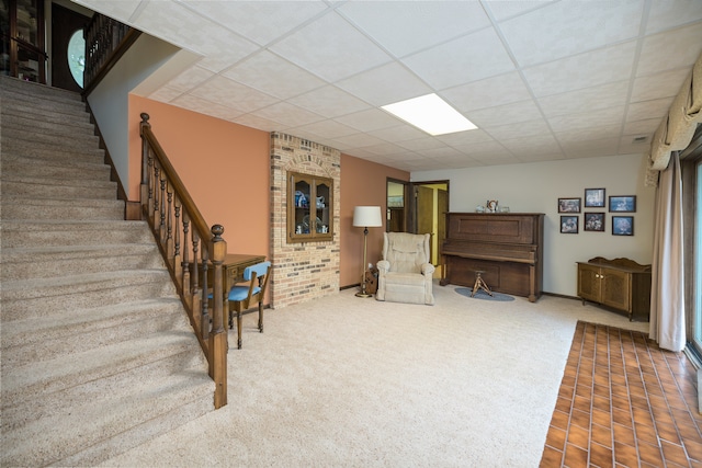 living area with carpet and a drop ceiling