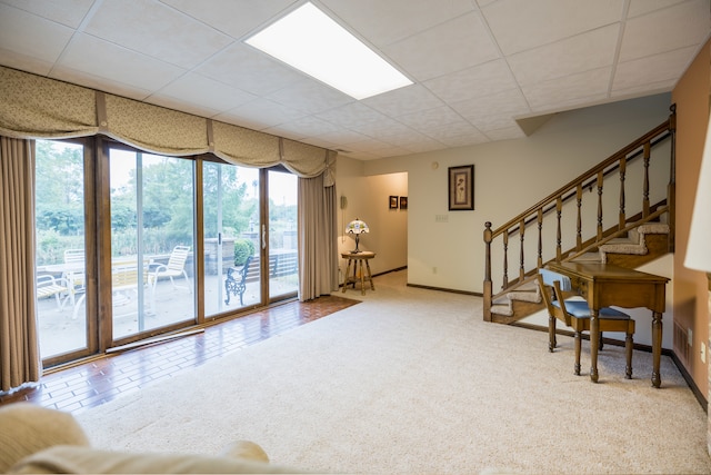 interior space featuring a drop ceiling, carpet floors, and a healthy amount of sunlight