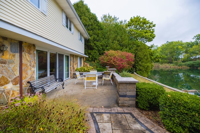 view of patio / terrace featuring a water view and a fire pit