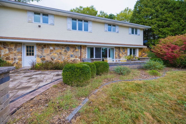 back of property with a patio and a lawn