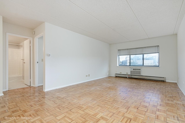 spare room with light parquet floors, a baseboard radiator, and a textured ceiling