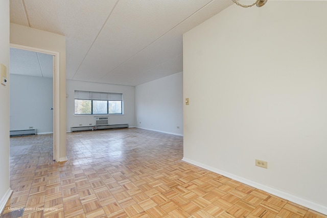 unfurnished room featuring a baseboard radiator, light parquet flooring, and a textured ceiling