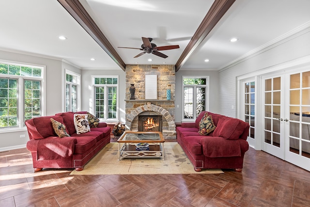 living room with a stone fireplace, beam ceiling, french doors, and plenty of natural light