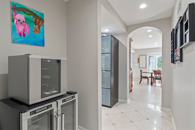 bar featuring beverage cooler and stainless steel refrigerator