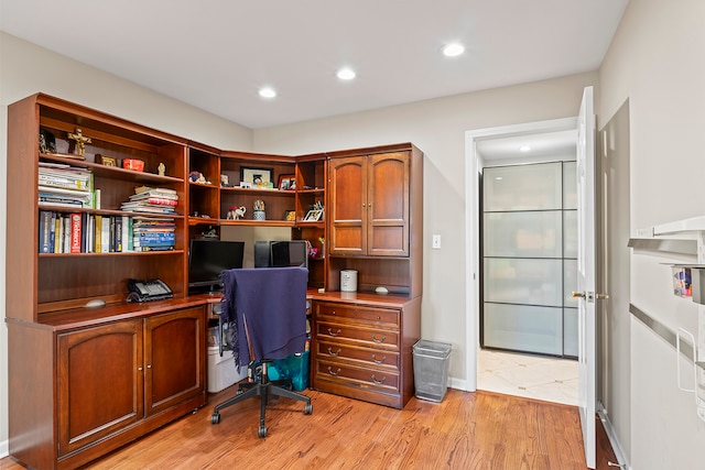 home office with light hardwood / wood-style floors