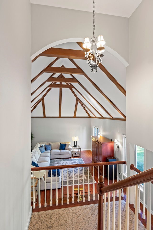 bedroom featuring a notable chandelier, hardwood / wood-style floors, and high vaulted ceiling