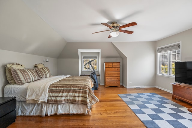 bedroom featuring wood-type flooring, vaulted ceiling, ceiling fan, and multiple windows