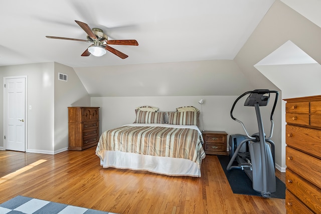 bedroom featuring ceiling fan, hardwood / wood-style flooring, and vaulted ceiling