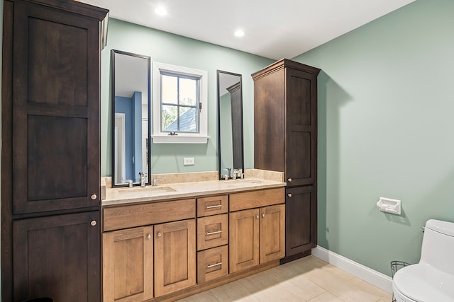 bathroom with tile patterned flooring, vanity, and toilet