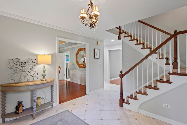 entrance foyer featuring a notable chandelier, light wood-type flooring, and crown molding