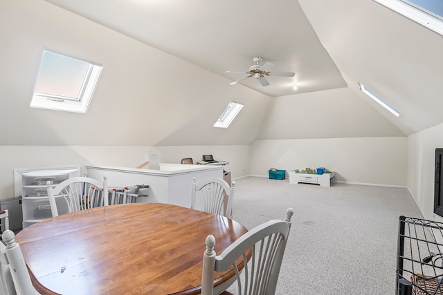 dining area featuring carpet floors, lofted ceiling with skylight, and ceiling fan