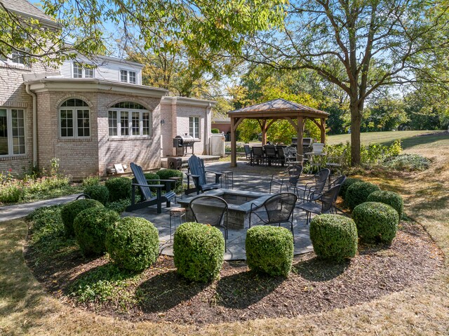 view of patio featuring an outdoor fire pit and a gazebo