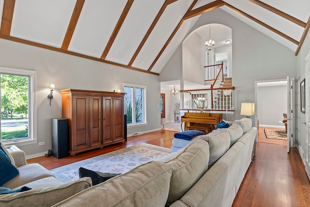 living room with high vaulted ceiling, wood-type flooring, and a chandelier