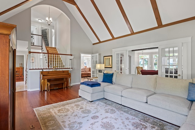 living room featuring high vaulted ceiling, an inviting chandelier, beamed ceiling, and dark wood-type flooring