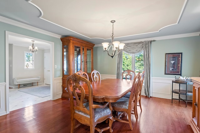 dining area with ornamental molding, dark hardwood / wood-style flooring, and a chandelier