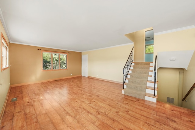 unfurnished living room with crown molding and light hardwood / wood-style flooring