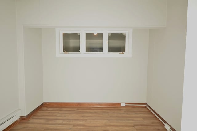 unfurnished room with light hardwood / wood-style floors and baseboard heating