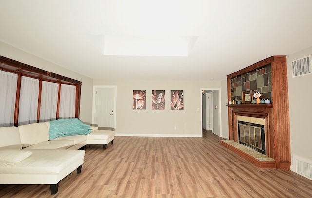 living room with a large fireplace and hardwood / wood-style flooring