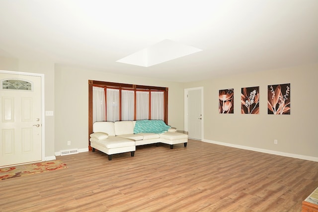 unfurnished bedroom with light wood-type flooring and a skylight