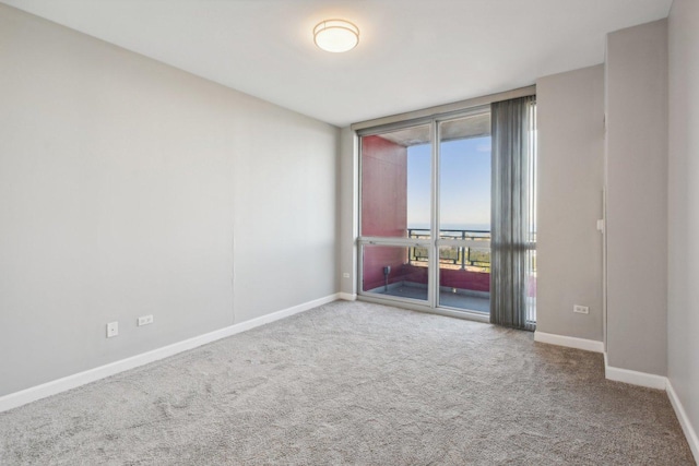 unfurnished room featuring carpet floors and baseboards