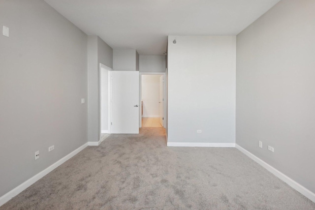 carpeted empty room with baseboards
